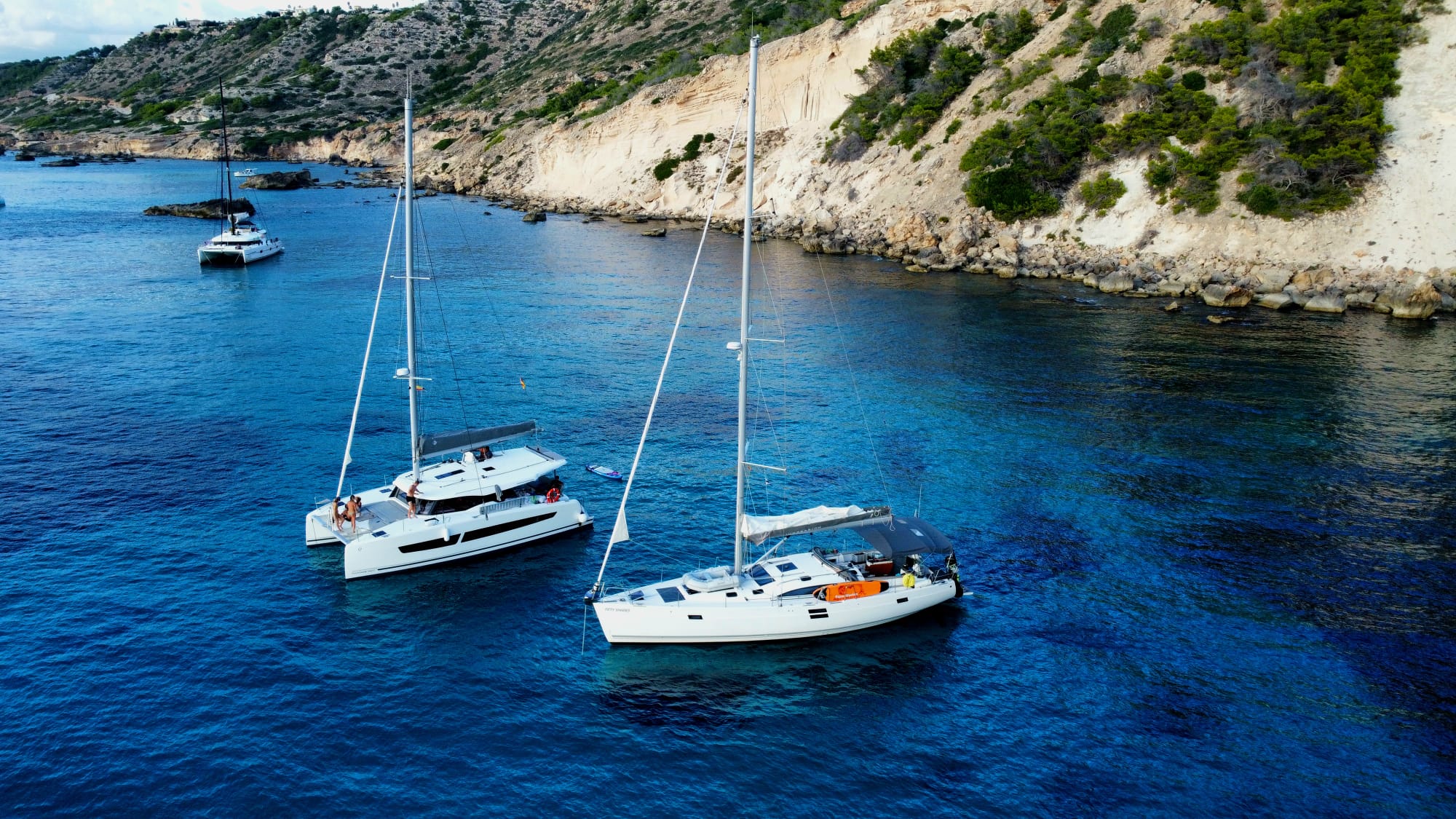 Yachts anchored in a sheltered cove near the cliffs