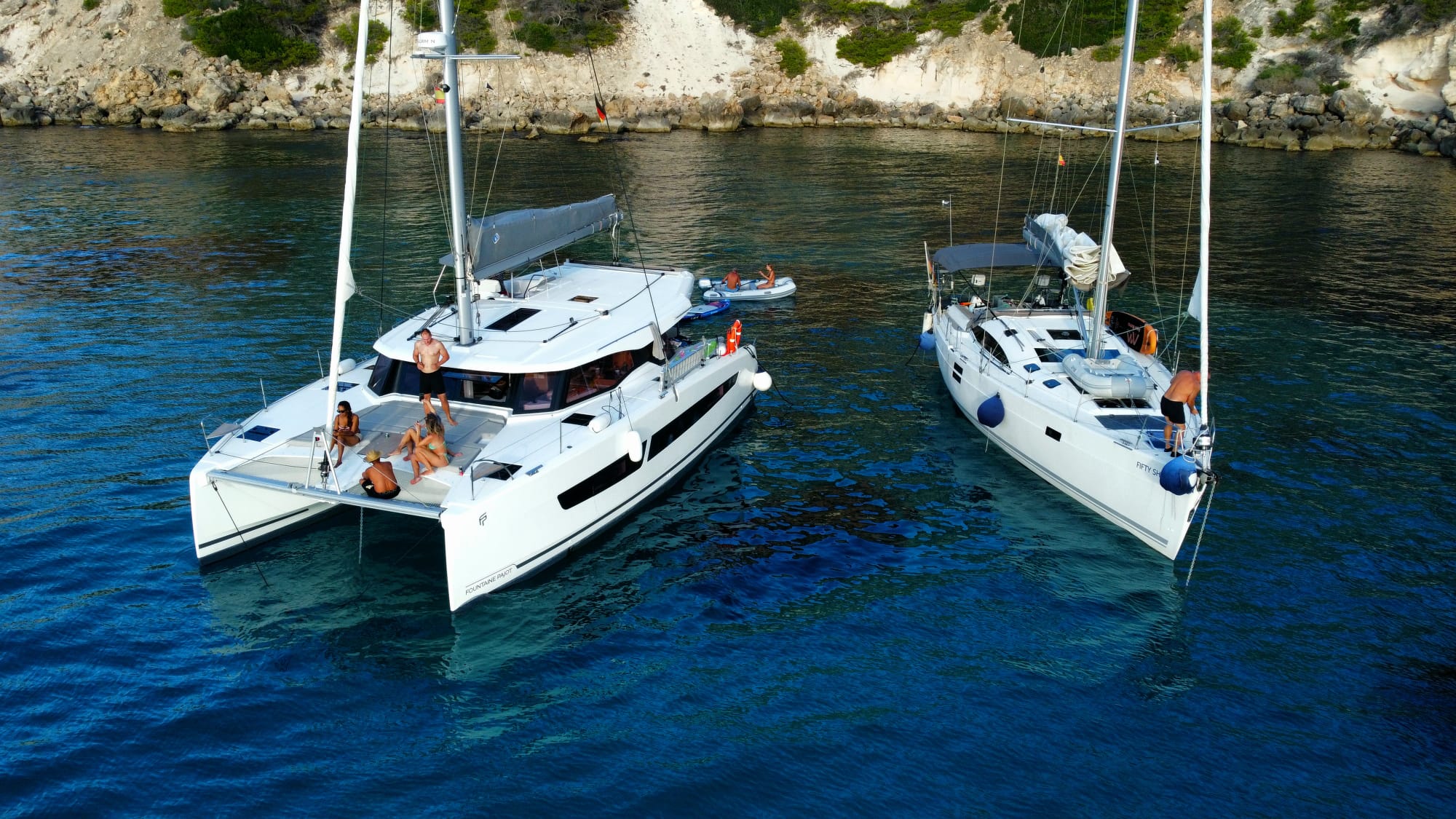 Commercial yachts moored side by side in clear Mediterranean water